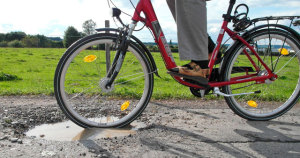 Foto: Fahrrad fährt in Schlagloch