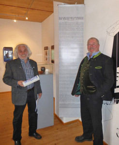 Der Vorsitzende des Auerbergmuseums Helmut Gehlert (rechts) und der Autor Hans Schütz, dazwischen das Textbanner mit der »Ballade von der Vertreibung der Römer vom Auerberg« Foto: Heinz Engl